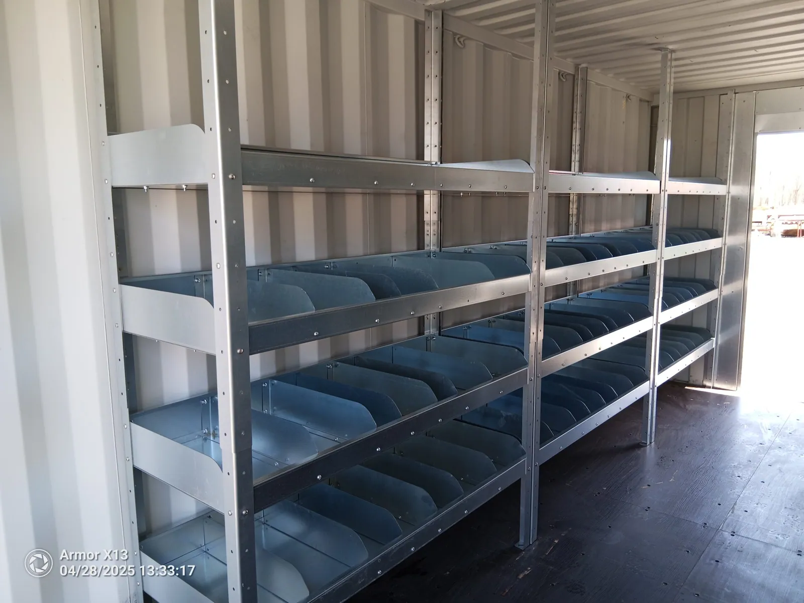 Galvanized Insula shelving installed along the wall of a shipping container
